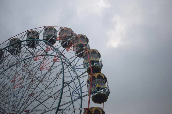 Delhi, Hindistan 'da Dussehra Mela sırasında çok renkli Dev Tekerlek' in yakın çekimi. Dev tekerlek salıncağının alt görüntüsü. Akşam vakti renkli kamaraları olan dönme dolap..