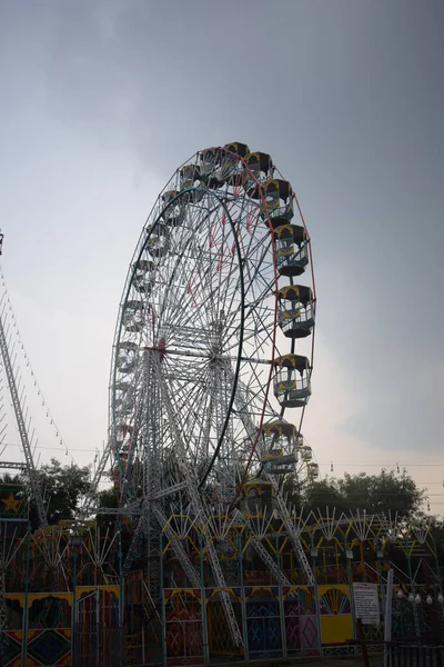Delhi, Hindistan 'da Dussehra Mela sırasında çok renkli Dev Tekerlek' in yakın çekimi. Dev tekerlek salıncağının alt görüntüsü. Akşam vakti renkli kamaraları olan dönme dolap..