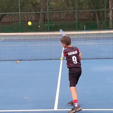 Delhi, Hindistan, 17 Şubat 2025 - Maha Open için kil tenis kortunda antrenörlük yapan genç tenisçiler, yaklaşan turnuva için küçük tenis oyuncuları antrenman yapıyor