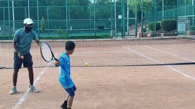 Delhi, Hindistan, 17 Şubat 2025 - Maha Open için kil tenis kortunda antrenörlük yapan genç tenisçiler, yaklaşan turnuva için küçük tenis oyuncuları antrenman yapıyor