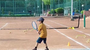 Delhi, Hindistan, 17 Şubat 2025 - Maha Open için kil tenis kortunda antrenörlük yapan genç tenisçiler, yaklaşan turnuva için küçük tenis oyuncuları antrenman yapıyor