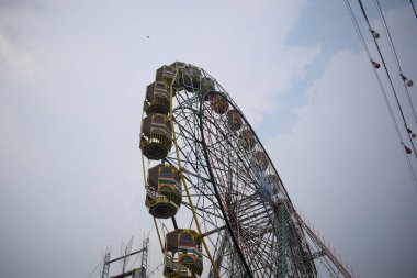 Delhi, Hindistan 'da Dussehra Mela sırasında çok renkli Dev Tekerlek' in yakın çekimi. Dev tekerlek salıncağının alt görüntüsü. Akşam vakti renkli kamaraları olan dönme dolap..