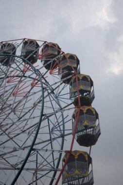 Delhi, Hindistan 'da Dussehra Mela sırasında çok renkli Dev Tekerlek' in yakın çekimi. Dev tekerlek salıncağının alt görüntüsü. Akşam vakti renkli kamaraları olan dönme dolap..