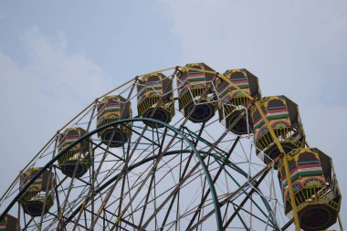 Delhi, Hindistan 'da Dussehra Mela sırasında çok renkli Dev Tekerlek' in yakın çekimi. Dev tekerlek salıncağının alt görüntüsü. Akşam vakti renkli kamaraları olan dönme dolap..