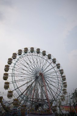 Delhi, Hindistan 'da Dussehra Mela sırasında çok renkli Dev Tekerlek' in yakın çekimi. Dev tekerlek salıncağının alt görüntüsü. Akşam vakti renkli kamaraları olan dönme dolap..