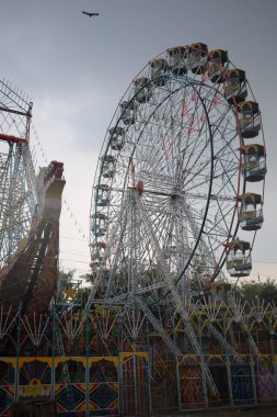 Delhi, Hindistan 'da Dussehra Mela sırasında çok renkli Dev Tekerlek' in yakın çekimi. Dev tekerlek salıncağının alt görüntüsü. Akşam vakti renkli kamaraları olan dönme dolap..
