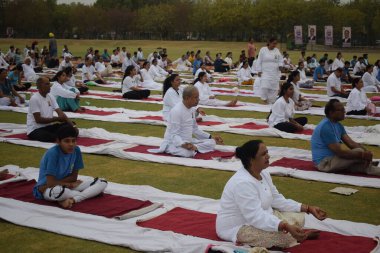 Yeni Delhi, Hindistan, 21 Haziran 2025 - Uluslararası Yoga Günü 'nde Delhi' deki Yamuna Spor Kompleksi 'nde grup Yoga egzersiz oturumu, kriket stadyumunda yoga sınıfına katılan büyük bir grup yetişkin