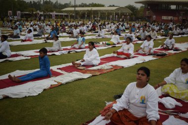 Yeni Delhi, Hindistan, 21 Haziran 2025 - Uluslararası Yoga Günü 'nde Delhi' deki Yamuna Spor Kompleksi 'nde grup Yoga egzersiz oturumu, kriket stadyumunda yoga sınıfına katılan büyük bir grup yetişkin