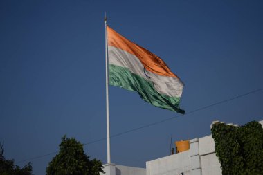 India flag flying high at Connaught Place with pride with plain white background, India flag fluttering, Indian Flag on Independence Day and Republic Day of India, tilt up shot, Har Ghar Tiranga