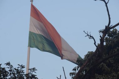 India flag flying high at Connaught Place with pride with plain white background, India flag fluttering, Indian Flag on Independence Day and Republic Day of India, tilt up shot, Har Ghar Tiranga