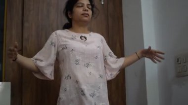 Evde yoga yapan genç Hintli bir kadın çevrimiçi yoga seansında güzel bir kız temel yoga pozisyonunda Asyalı bir kadın kapalı alanda yoga yapıyor.