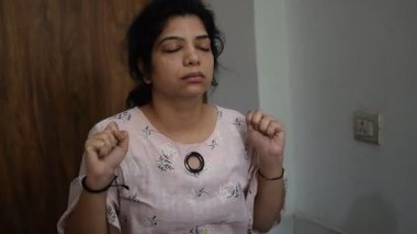 Evde yoga yapan genç Hintli bir kadın çevrimiçi yoga seansında güzel bir kız temel yoga pozisyonunda Asyalı bir kadın kapalı alanda yoga yapıyor.