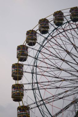 Delhi, Hindistan 'da Dussehra Mela sırasında çok renkli Dev Tekerlek' in yakın çekimi. Dev tekerlek salıncağının alt görüntüsü. Akşam vakti renkli kamaraları olan dönme dolap..