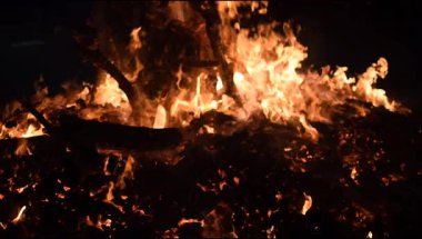 Siyah arka planda alevler, alev alev dokusu arka planda, çok güzel, ateş yanıyor, ateş odun ve inek gübresi ateşiyle yanıyor.