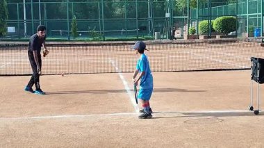 Delhi, Hindistan, 17 Şubat 2025 - Maha Open için kil tenis kortunda antrenörlük yapan genç tenisçiler, yaklaşan turnuva için küçük tenis oyuncuları antrenman yapıyor