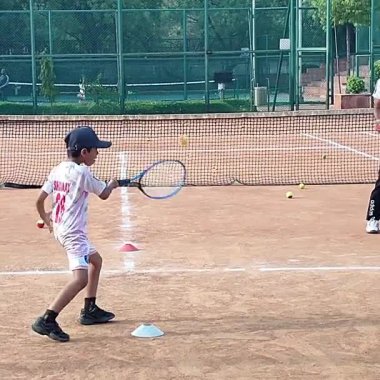 Delhi, Hindistan, 17 Şubat 2025 - Maha Open için kil tenis kortunda antrenörlük yapan genç tenisçiler, yaklaşan turnuva için küçük tenis oyuncuları antrenman yapıyor