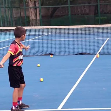 Delhi, Hindistan, 17 Şubat 2025 - Maha Open için kil tenis kortunda antrenörlük yapan genç tenisçiler, yaklaşan turnuva için küçük tenis oyuncuları antrenman yapıyor