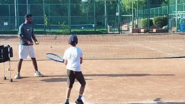 Delhi, Hindistan, 17 Şubat 2025 - Maha Open için kil tenis kortunda antrenörlük yapan genç tenisçiler, yaklaşan turnuva için küçük tenis oyuncuları antrenman yapıyor