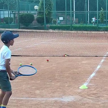 Delhi, Hindistan, 17 Şubat 2025 - Maha Open için kil tenis kortunda antrenörlük yapan genç tenisçiler, yaklaşan turnuva için küçük tenis oyuncuları antrenman yapıyor