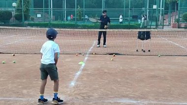 Delhi, Hindistan, 17 Şubat 2025 - Maha Open için kil tenis kortunda antrenörlük yapan genç tenisçiler, yaklaşan turnuva için küçük tenis oyuncuları antrenman yapıyor
