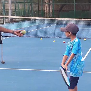 Delhi, Hindistan, 17 Şubat 2025 - Maha Open için kil tenis kortunda antrenörlük yapan genç tenisçiler, yaklaşan turnuva için küçük tenis oyuncuları antrenman yapıyor