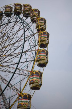 Delhi, Hindistan 'da Dussehra Mela sırasında çok renkli Dev Tekerlek' in yakın çekimi. Dev tekerlek salıncağının alt görüntüsü. Akşam vakti renkli kamaraları olan dönme dolap..
