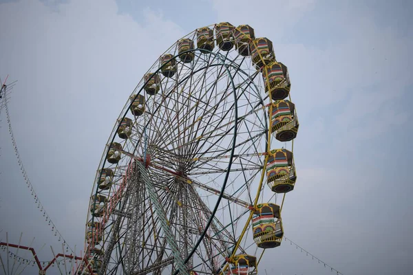 Delhi, Hindistan 'da Dussehra Mela sırasında çok renkli Dev Tekerlek' in yakın çekimi. Dev tekerlek salıncağının alt görüntüsü. Akşam vakti renkli kamaraları olan dönme dolap..