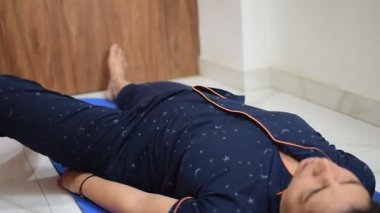 Evde yoga yapan genç Hintli bir kadın çevrimiçi yoga seansında güzel bir kız temel yoga pozisyonunda Asyalı bir kadın kapalı alanda yoga yapıyor.