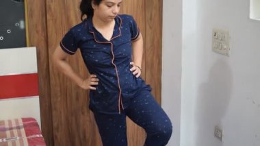 Evde yoga yapan genç Hintli bir kadın çevrimiçi yoga seansında güzel bir kız temel yoga pozisyonunda Asyalı bir kadın kapalı alanda yoga yapıyor.