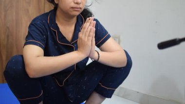 Evde yoga yapan genç Hintli bir kadın çevrimiçi yoga seansında güzel bir kız temel yoga pozisyonunda Asyalı bir kadın kapalı alanda yoga yapıyor.