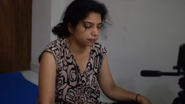Evde yoga yapan genç Hintli bir kadın çevrimiçi yoga seansında güzel bir kız temel yoga pozisyonunda Asyalı bir kadın kapalı alanda yoga yapıyor.