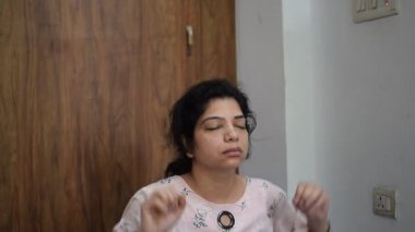 Evde yoga yapan genç Hintli bir kadın çevrimiçi yoga seansında güzel bir kız temel yoga pozisyonunda Asyalı bir kadın kapalı alanda yoga yapıyor.