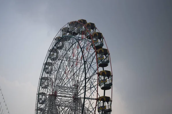 Delhi, Hindistan 'da Dussehra Mela sırasında çok renkli Dev Tekerlek' in yakın çekimi. Dev tekerlek salıncağının alt görüntüsü. Akşam vakti renkli kamaraları olan dönme dolap..