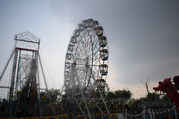 Delhi, Hindistan 'da Dussehra Mela sırasında çok renkli Dev Tekerlek' in yakın çekimi. Dev tekerlek salıncağının alt görüntüsü. Akşam vakti renkli kamaraları olan dönme dolap..
