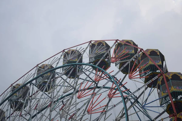 Delhi, Hindistan 'da Dussehra Mela sırasında çok renkli Dev Tekerlek' in yakın çekimi. Dev tekerlek salıncağının alt görüntüsü. Akşam vakti renkli kamaraları olan dönme dolap..