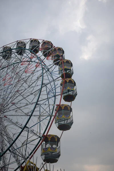 Delhi, Hindistan 'da Dussehra Mela sırasında çok renkli Dev Tekerlek' in yakın çekimi. Dev tekerlek salıncağının alt görüntüsü. Akşam vakti renkli kamaraları olan dönme dolap..