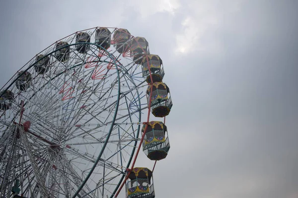 Delhi, Hindistan 'da Dussehra Mela sırasında çok renkli Dev Tekerlek' in yakın çekimi. Dev tekerlek salıncağının alt görüntüsü. Akşam vakti renkli kamaraları olan dönme dolap..