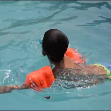 Havuzda yüzen mutlu Hintli çocuk, sıcak yaz tatillerinde hava tüpüyle birlikte yüzen çocuk, büyük bir havuzda yüzen çocuk..