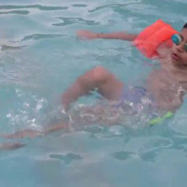 Havuzda yüzen mutlu Hintli çocuk, sıcak yaz tatillerinde hava tüpüyle birlikte yüzen çocuk, büyük bir havuzda yüzen çocuk..