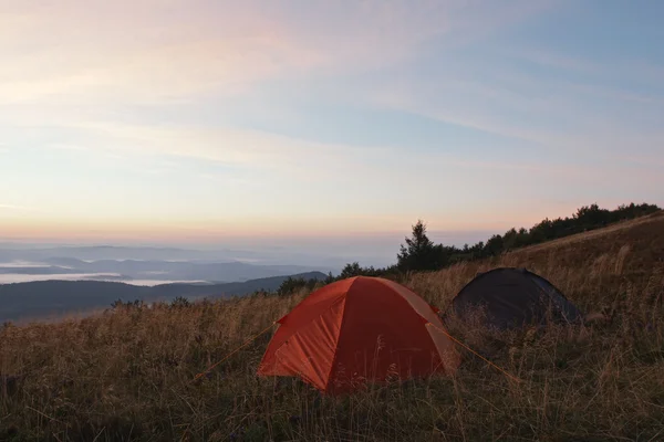 Tents at sunrise in mountains — Stock Photo, Image