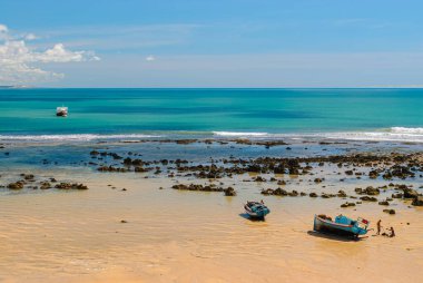 Pipa plajı, Tibau do Sul, 7 Mayıs 2008 'de Brezilya, Rio Grande do Norte yakınlarında. Balıkçı tekneleri güneşli bir günde zümrüt denize demir attı..