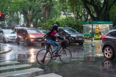Yağmurlu bir günde Buenos Aires, Arjantin 'de Recoleta Mahallesi' nde arabaların arasından geçen bisikletçi 11 Aralık 2018 'de.
