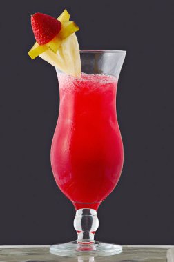 Gri arka planda cam kasede meyve kokteyli..