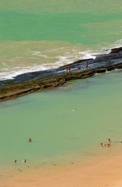 11 Nisan 2005 'te Praia de Boa Viagem, Recife, Pernambuco, Brezilya' da suda ve kumda yaşayan insanlar ve arka planda resifler vardı..