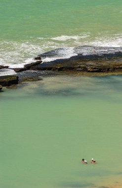11 Nisan 2005 'te Praia de Boa Viagem, Recife, Pernambuco, Brezilya' da suda ve kumda yaşayan insanlar ve arka planda resifler vardı..