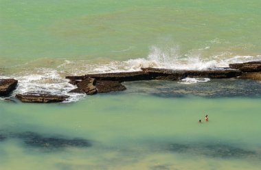 11 Nisan 2005 'te Praia de Boa Viagem, Recife, Pernambuco, Brezilya' da suda ve kumda yaşayan insanlar ve arka planda resifler vardı..
