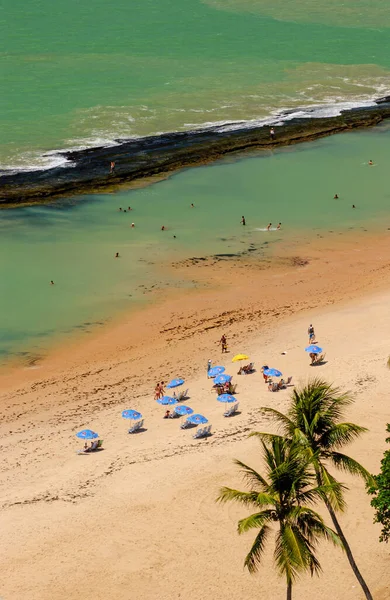 11 Nisan 2005 'te Praia de Boa Viagem, Recife, Pernambuco, Brezilya' da suda ve kumda yaşayan insanlar ve arka planda resifler vardı..