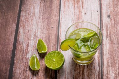 Eski ahşap bir masada limonlu bir bardak caipirinha. Tipik Brezilya içeceği cachaca, limon, buz ve şekerden yapılır..