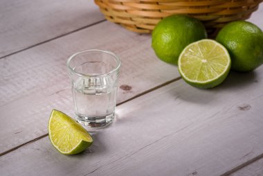 Küçük bardakta şeker kamışı likörü, limonlu ahşap bir masanın üzerinde. Rom 'a benzer tipik bir Brezilya içkisidir..