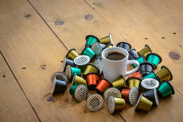 Coffee Cup Surrounded Used Coffee Capsules Wooden Table Stock Picture